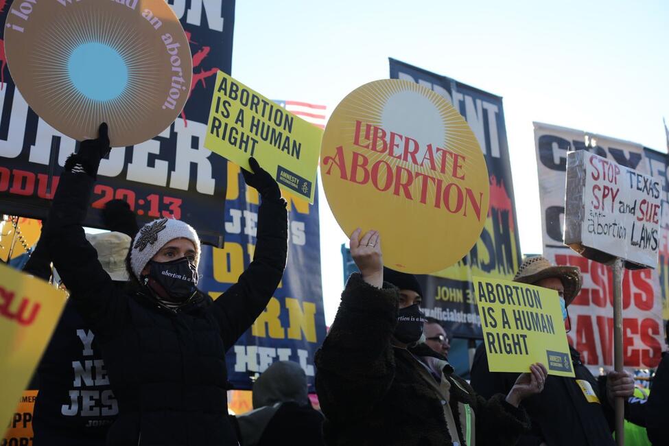 Eine Menschenmenge protestiert mit vielen Schildern, darunter auch Amnesty-Schilder mit der Aufschrift "Abortion is a human right"
