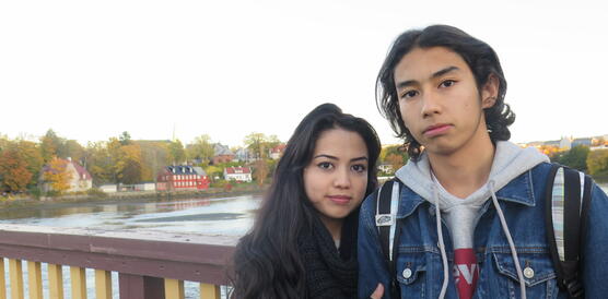Portätfoto von Taibeh Abbasi und ihrem Bruder Ehsan an einem Brückgeländer vor einem Gewässer
