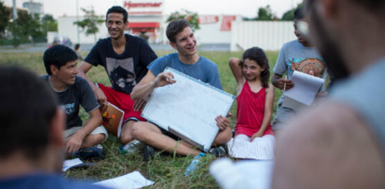 "Wie geht es Dir?" Deutschunterricht auf der Wiese vor der Flüchtlingsunterkunft in Heidenau