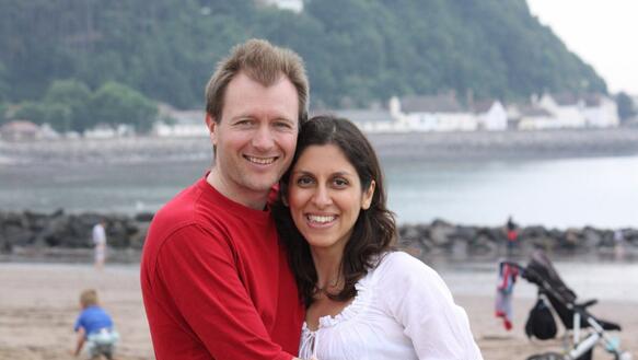 Das Bild zeigt das Ehepaar Nazanin Zaghari-Ratcliffe und Richard Ratcliffe, die vor einem Strand stehen.