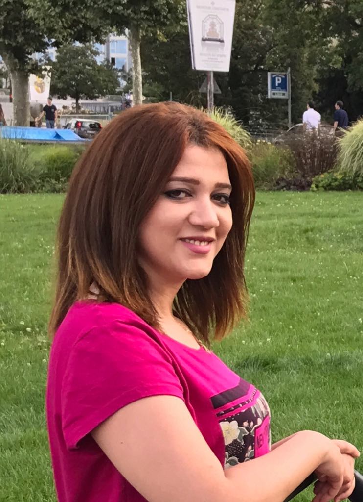 Ein Porträt von Amal Fathy vor einer Wiese