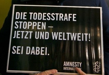 Ein schwarzes Plakat mit der Aufschrift: Die Todesstrafe stoppen - jetzt und weltweit! Sei dabei.
