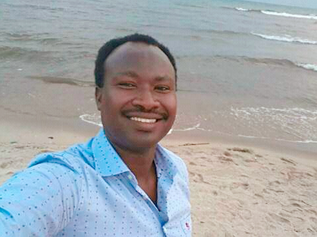 Porträtfoto von Germain Rukuki mit Meer im Hintergrund