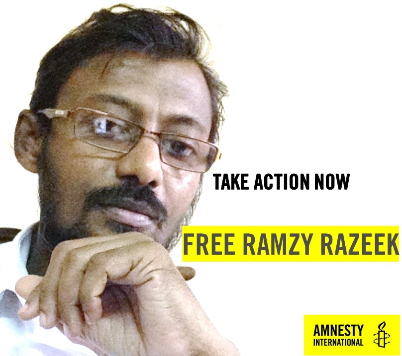 Die Grafik zeigt ein Porträtfoto von Ramzy Razeek. Er trägt eine Brille. Auf der Grafik steht unter anderem: "Free Ramzy Razeek".