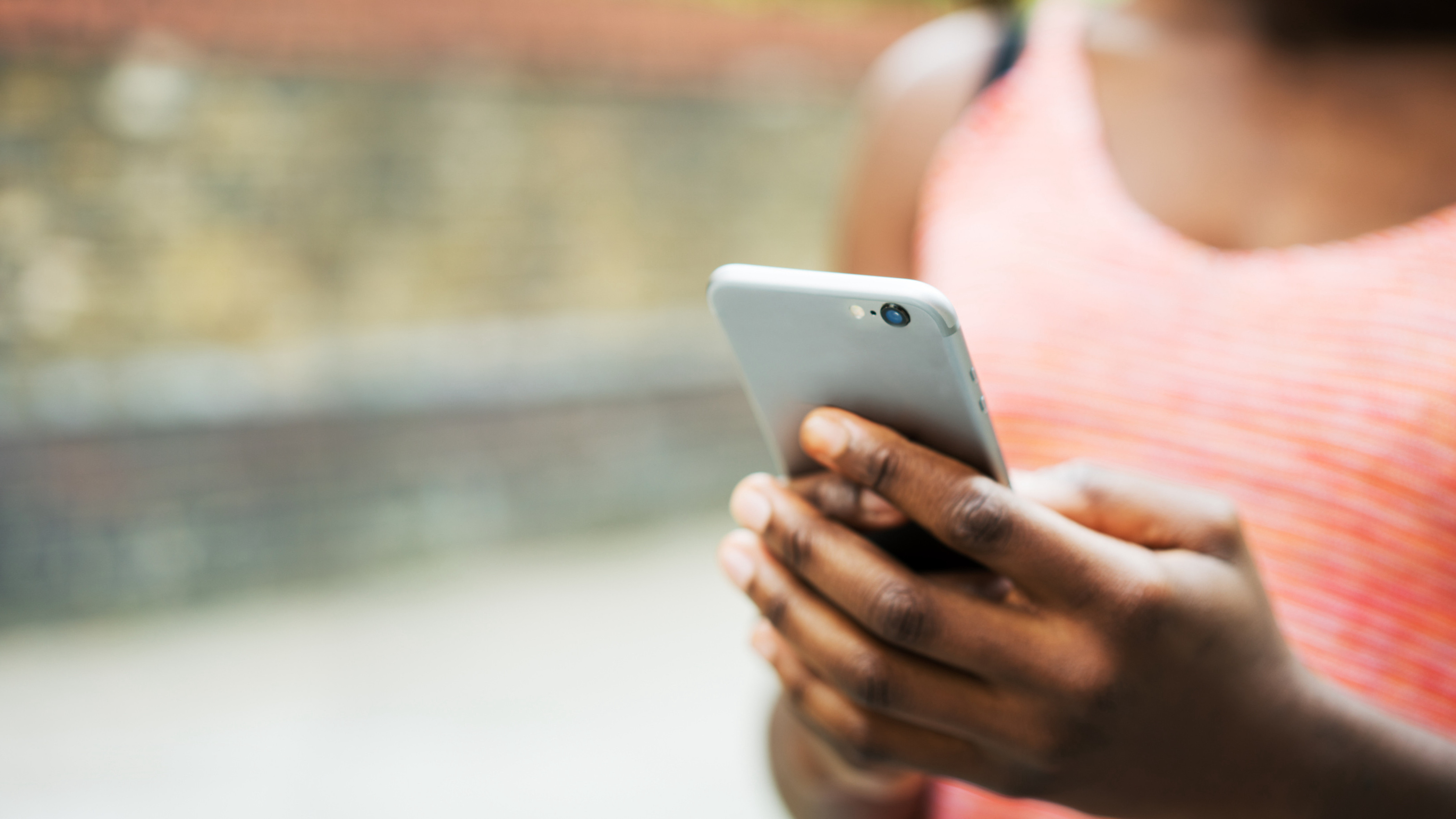Eine Person hält ein Smartphone in den Händen. 