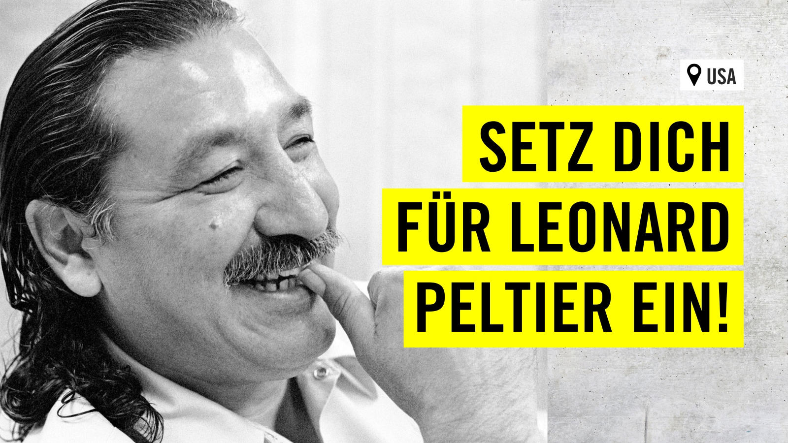 Schwarz-weiß Foto von einem Mann, der sich in der linken Bildhälfte befindet und lächelt. Rechts im Bild sind drei gelbe Banken mit der Aufschrift "USA: Setz dich für Leonard Peltier ein!"