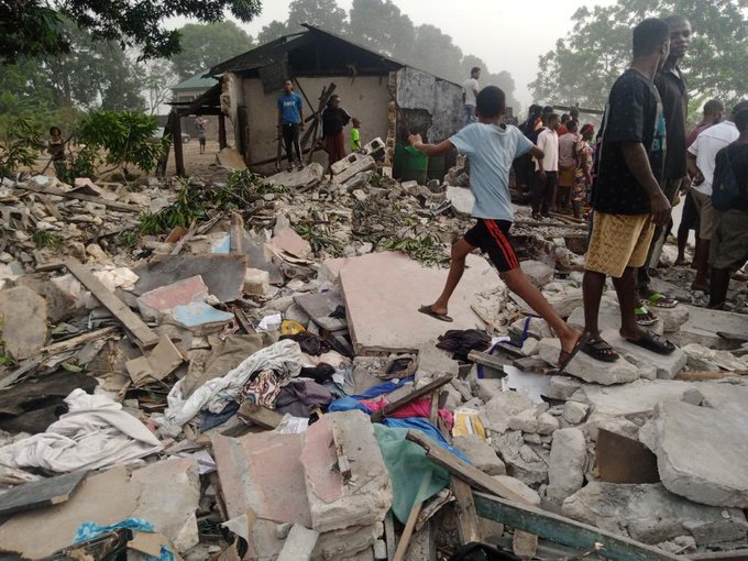Anwohner_innen der nigerianischen Stadt Port Harcourt stehen in den Trümmern ihrer Häuser