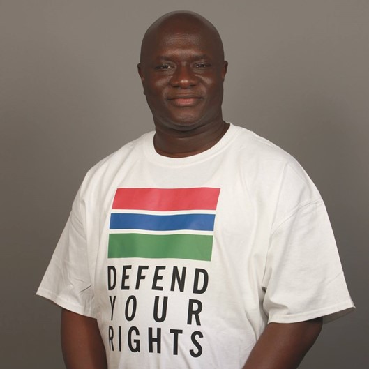 Ein dunkelhäutiger Mann, auf seinem T-Shirt steht: „Defend Your Rights".
