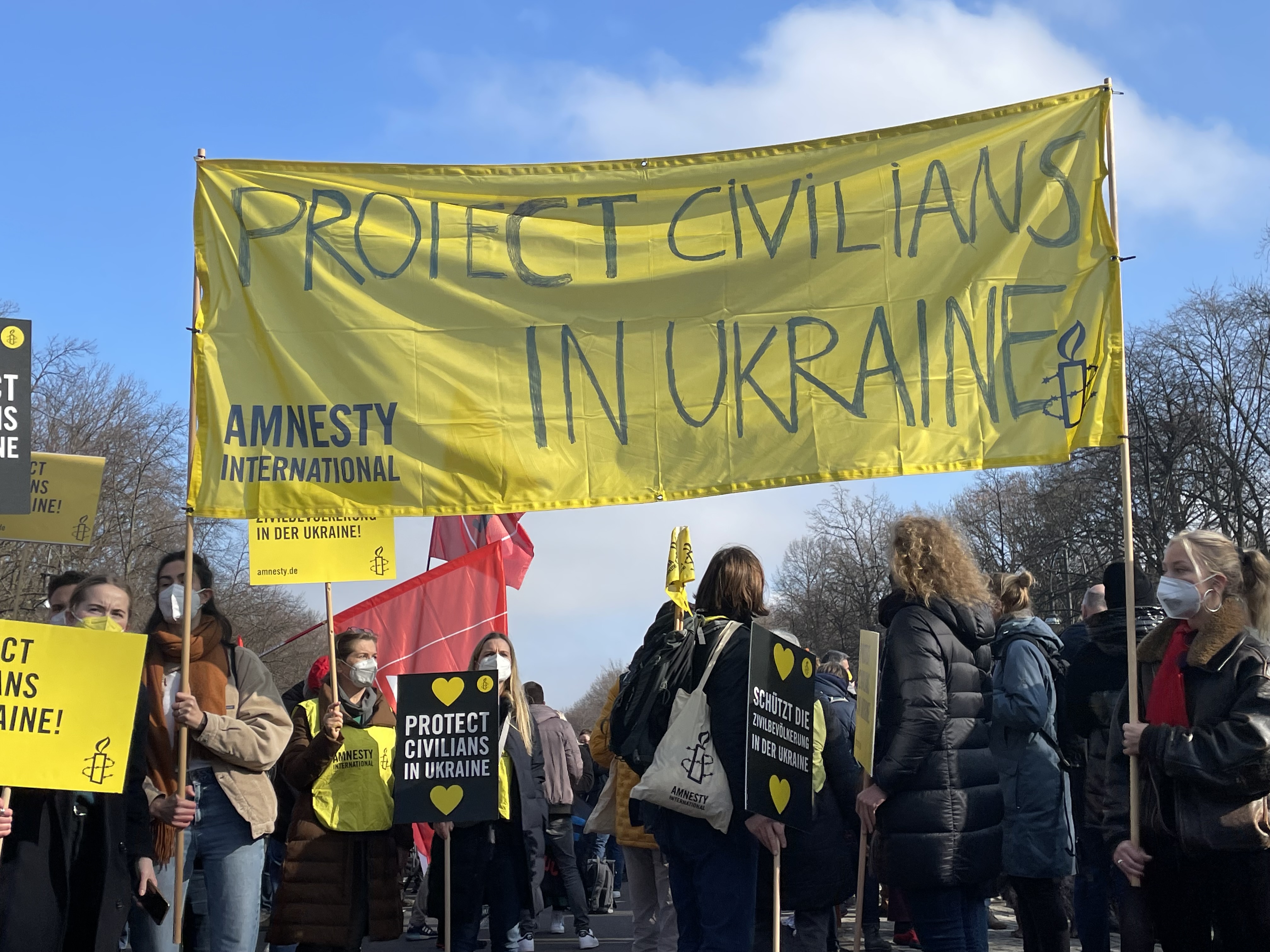 Das Bild zeigt mehrere Menschen mit Protestplakaten
