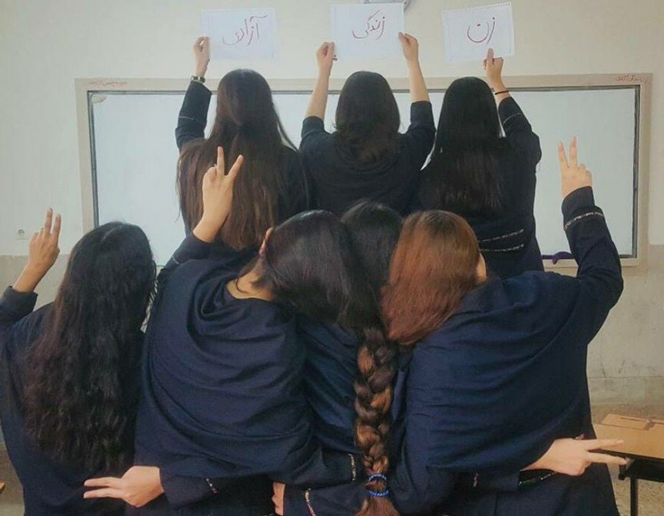 Das Bild zeigt mehrere junge Frauen, die von der Kamera wegschauen und das Victory-Zeichen machen