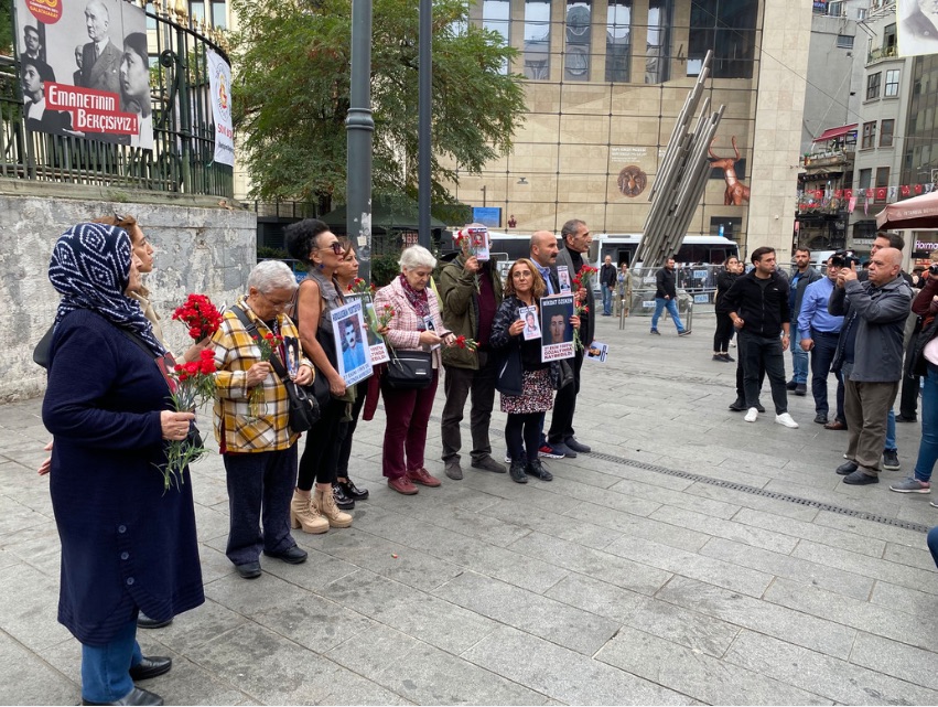 Das Bild zeigt mehrere Menschen mit Protestplakaten