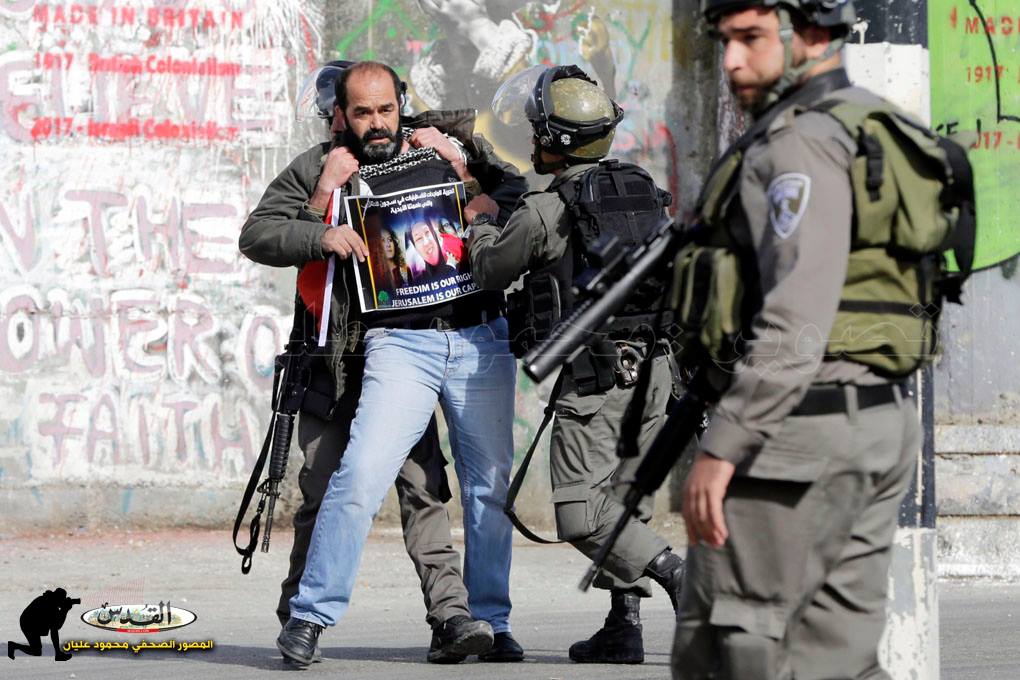 Das Bild zeigt Sicherheitskräfte mit Waffen, wie sie einen Mann festhalten
