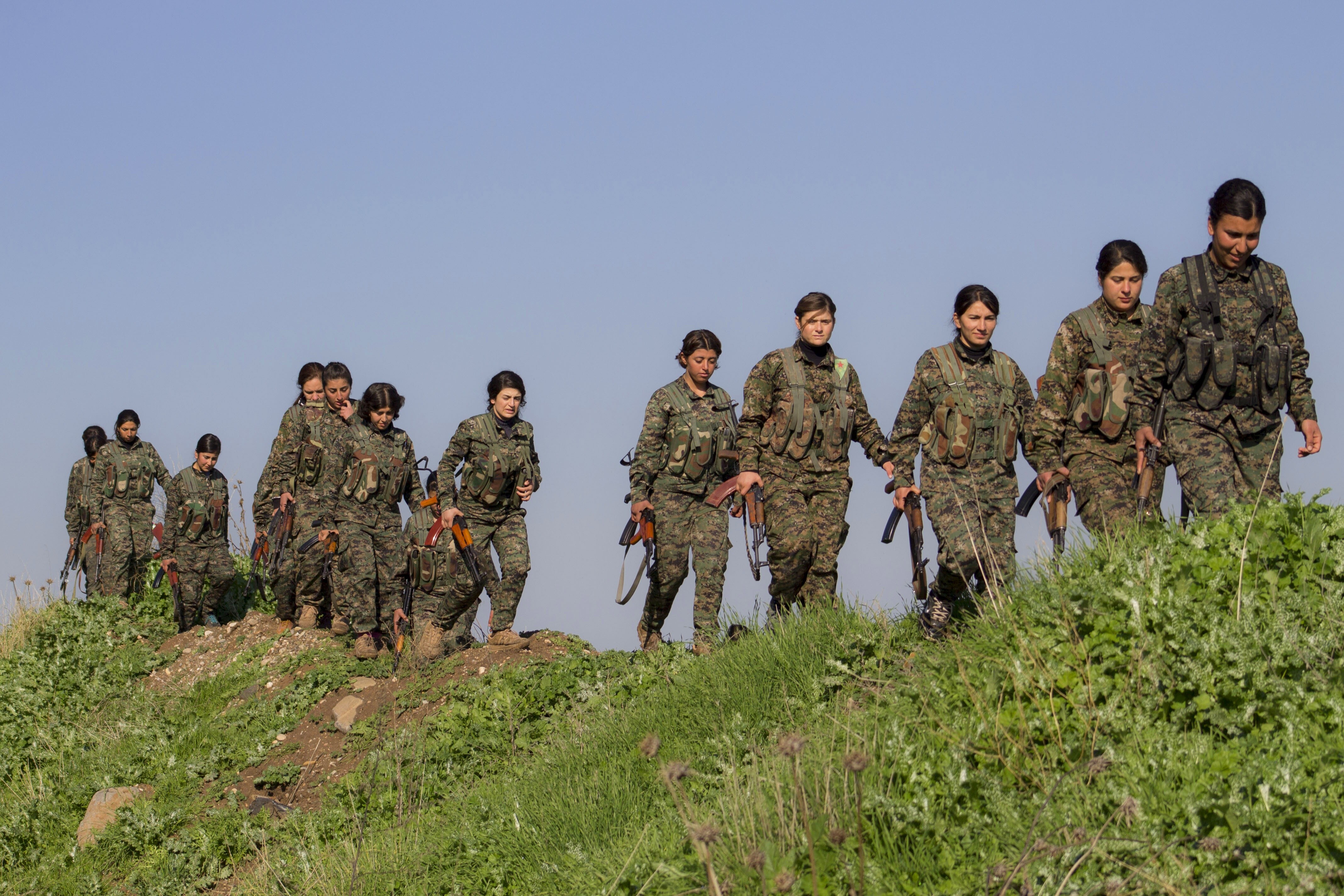 Das Bild zeigt mehrere Frauen in Uniform und mit Waffen