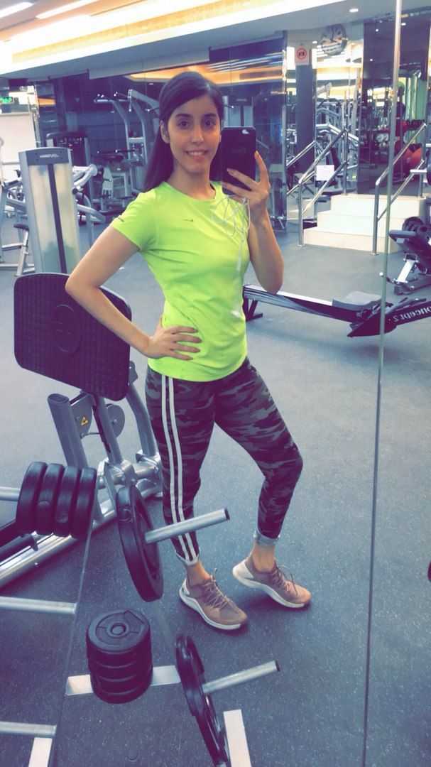 Das Bild zeigt das Selfie einer jungen Frau im Fitnessstudio