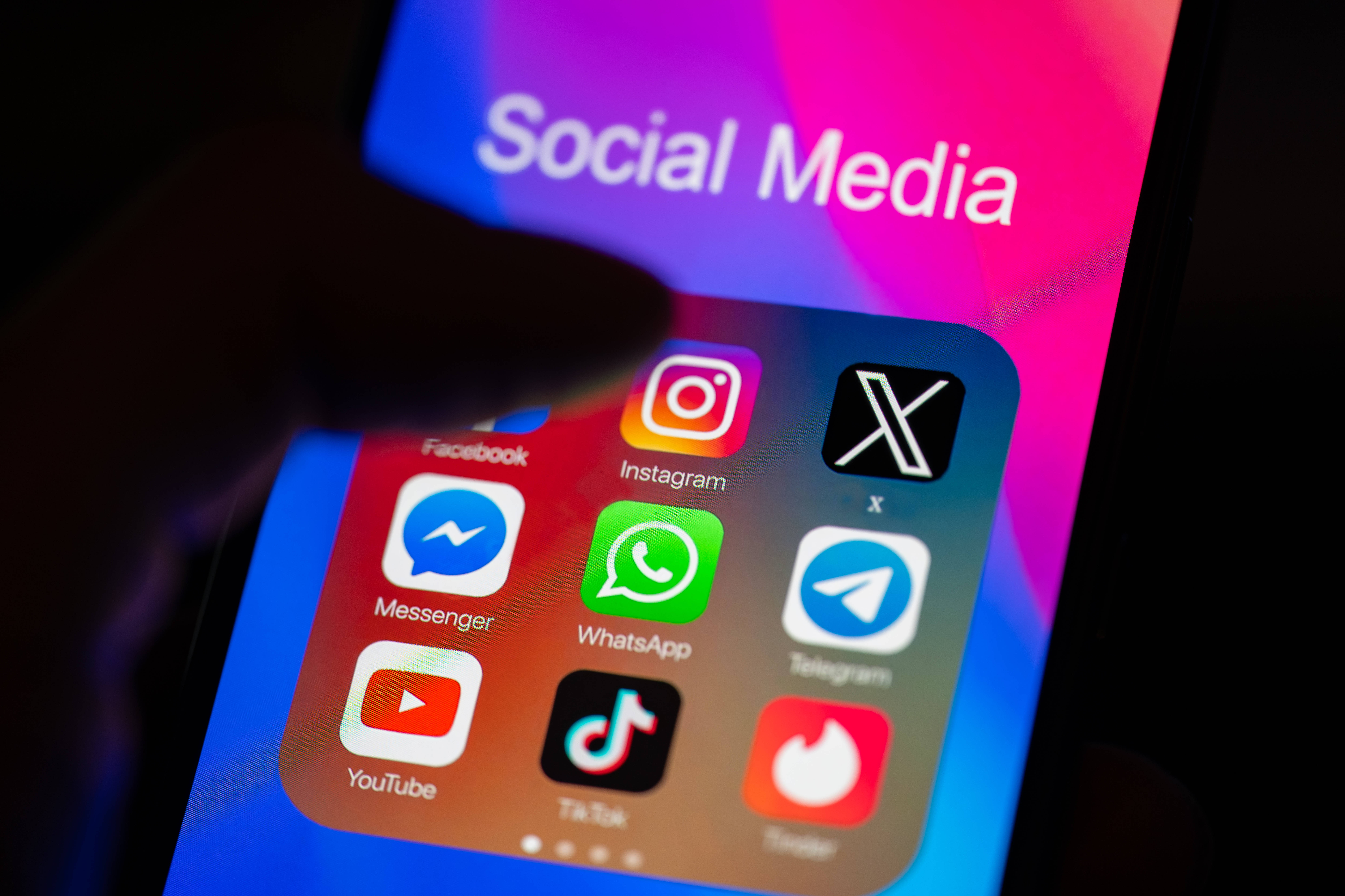 Das Foto zeigt einen Handy-Bildschirm mit den Apps von X, Instagram, Facebook, YouTube, TikTok und WhatsApp.