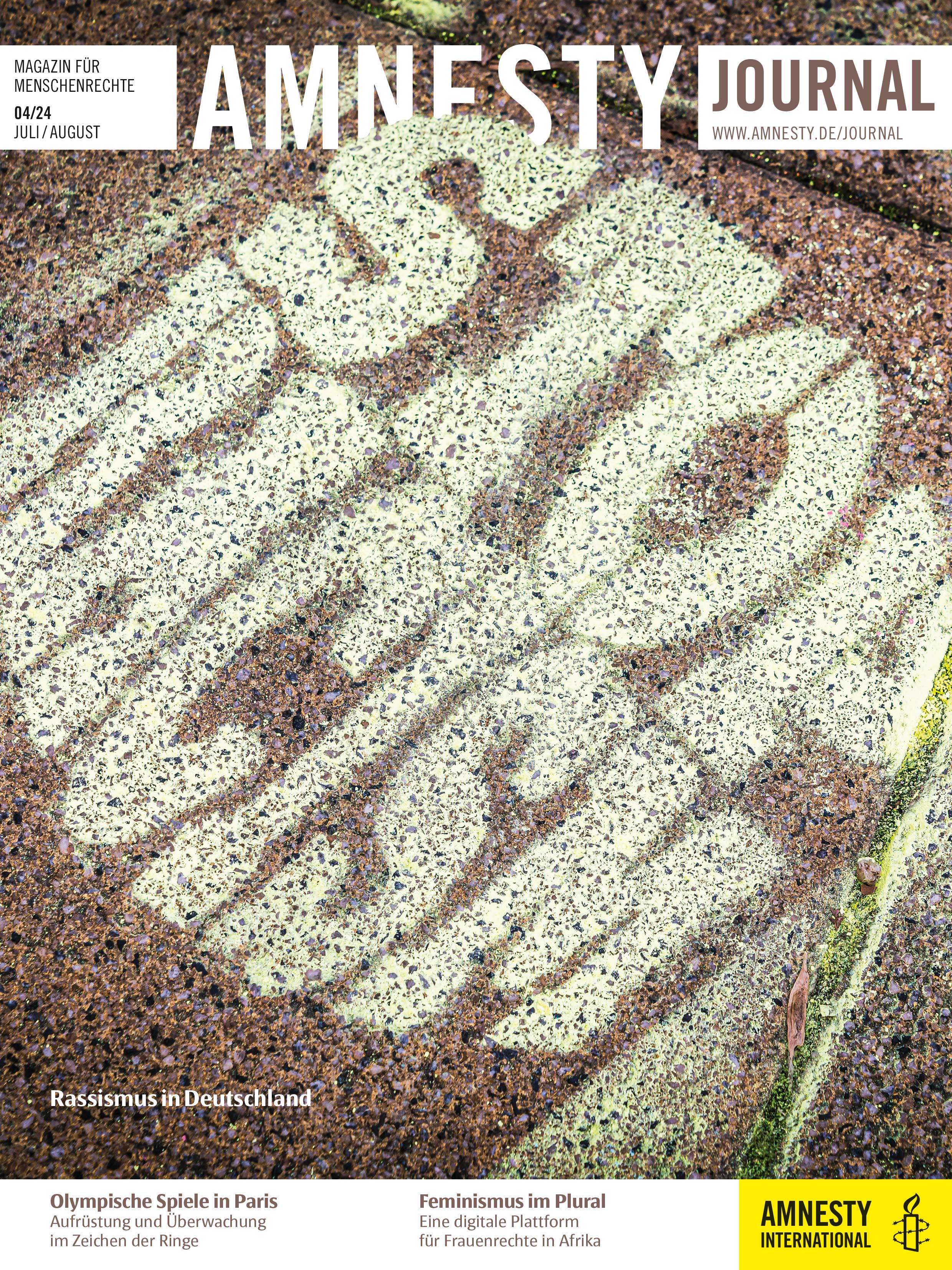 Ein mit Schablone gesprühtes Graffito auf Asphalt, "Stop Racism", steht dort; es ist Teil des Layouts der Coverseite des Amnesty Journals Juli/August 20024.