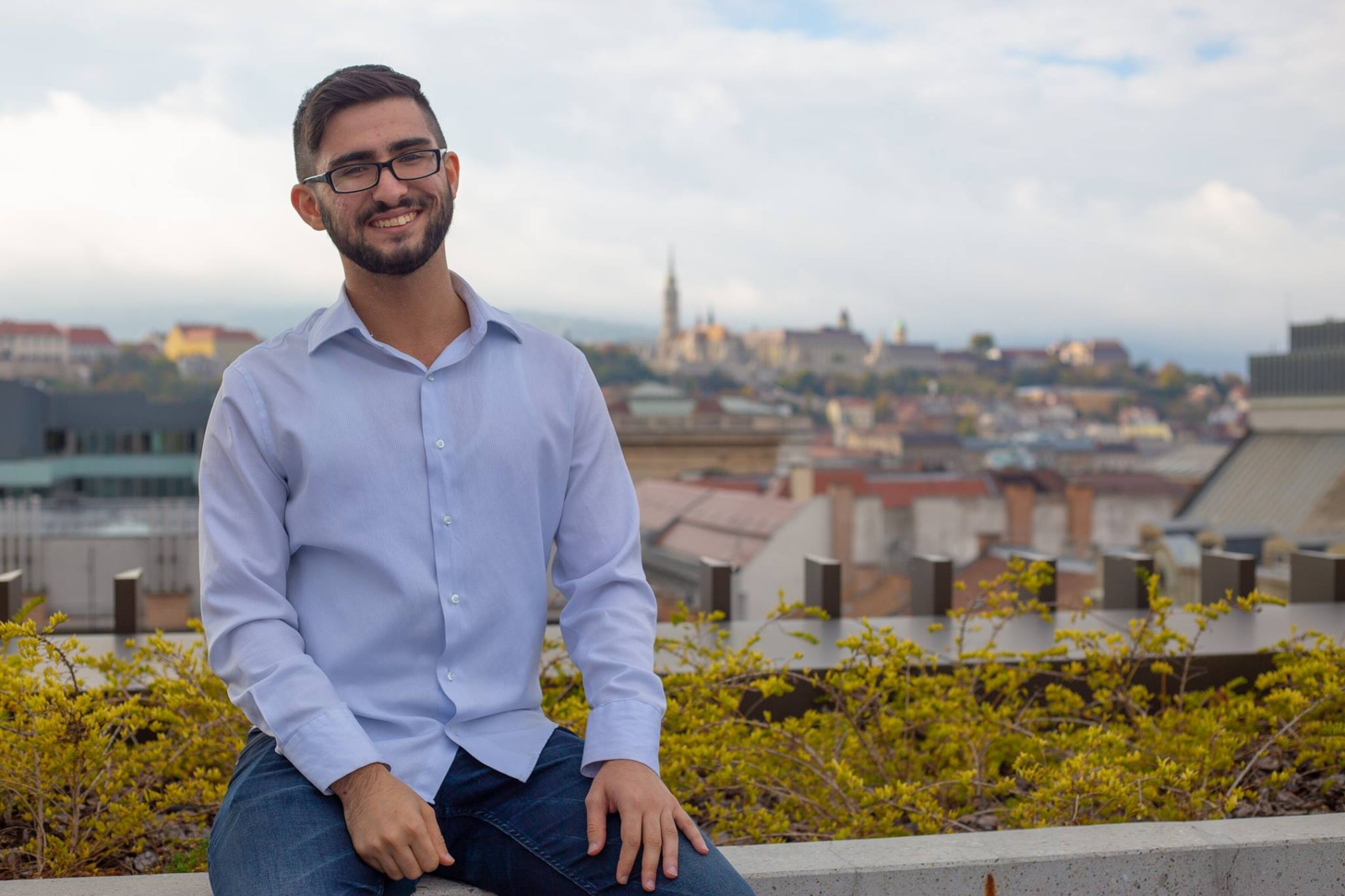 Das Foto zeigt Bahruz Samadov lächelnd vor dem Hintergrund eines Stadtpanoramas.