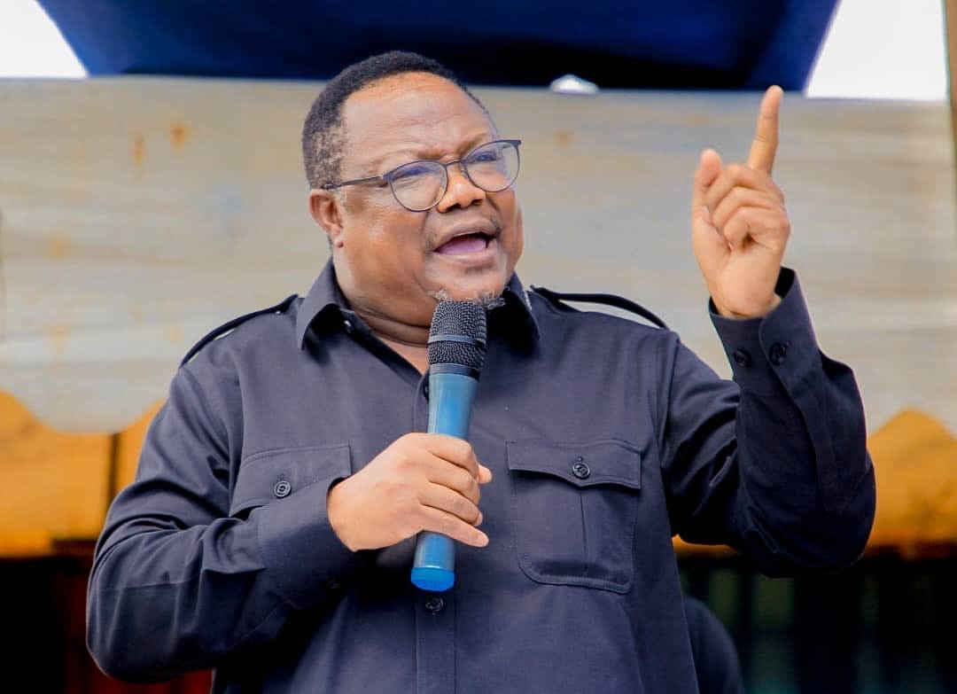 Das Foto zeigt Tundu Lissu bei einer Rede. Er hebt seinen linken Zeigefinger in die Luft. Mit seiner rechten Hand hält er ein Mikrofon vor seinen Mund.