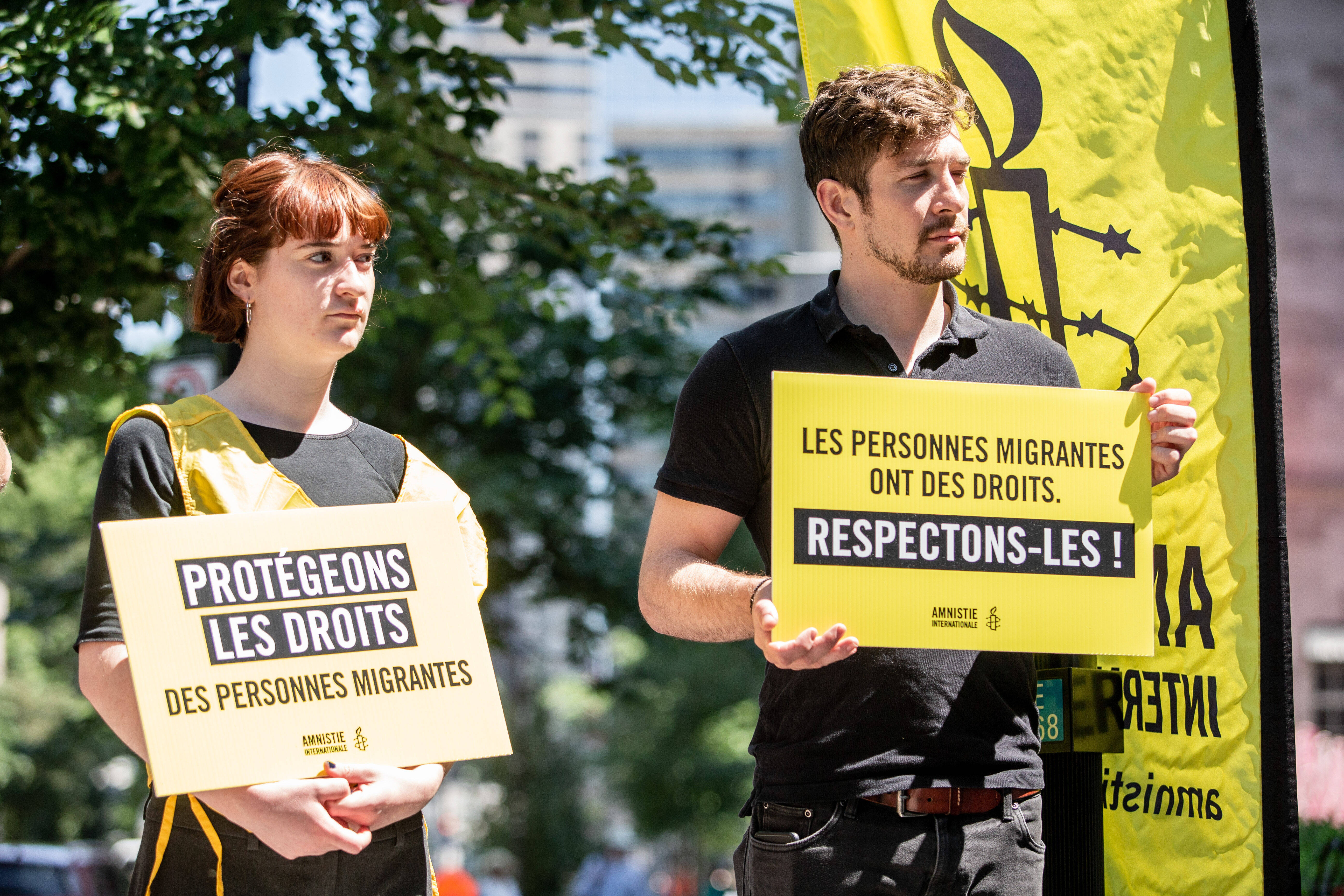 Zwei Personen mit Protestschildern
