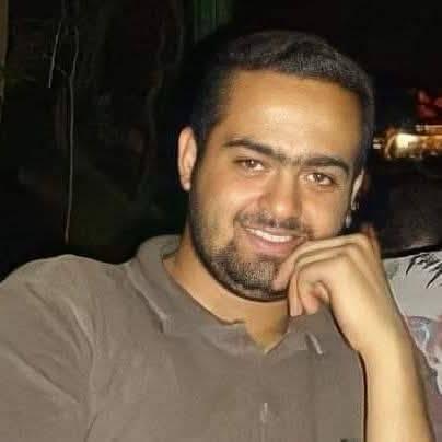 Porträtbild von Mohamed Adel. Er lächelt in die Kamera, hat kurze schwarze Haare