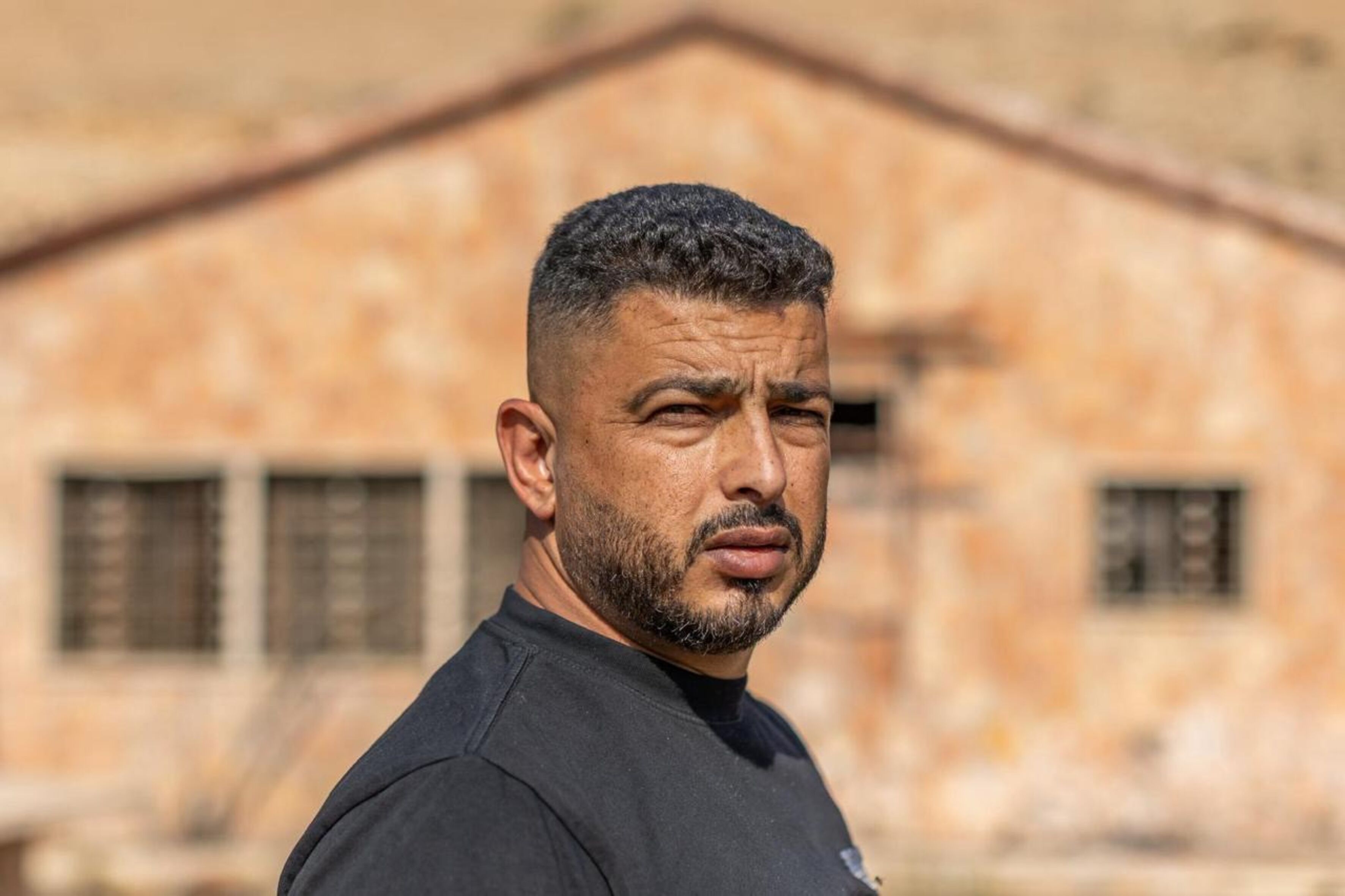 Porträtfoto von Ayman Bani Owda, der ernst in die Kamera blickt.