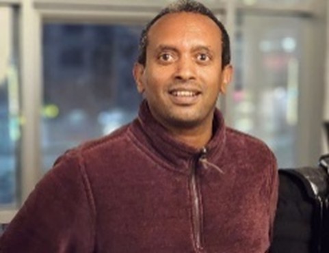 Porträtfoto von Million Beyene, der in die Kamera lächelt.