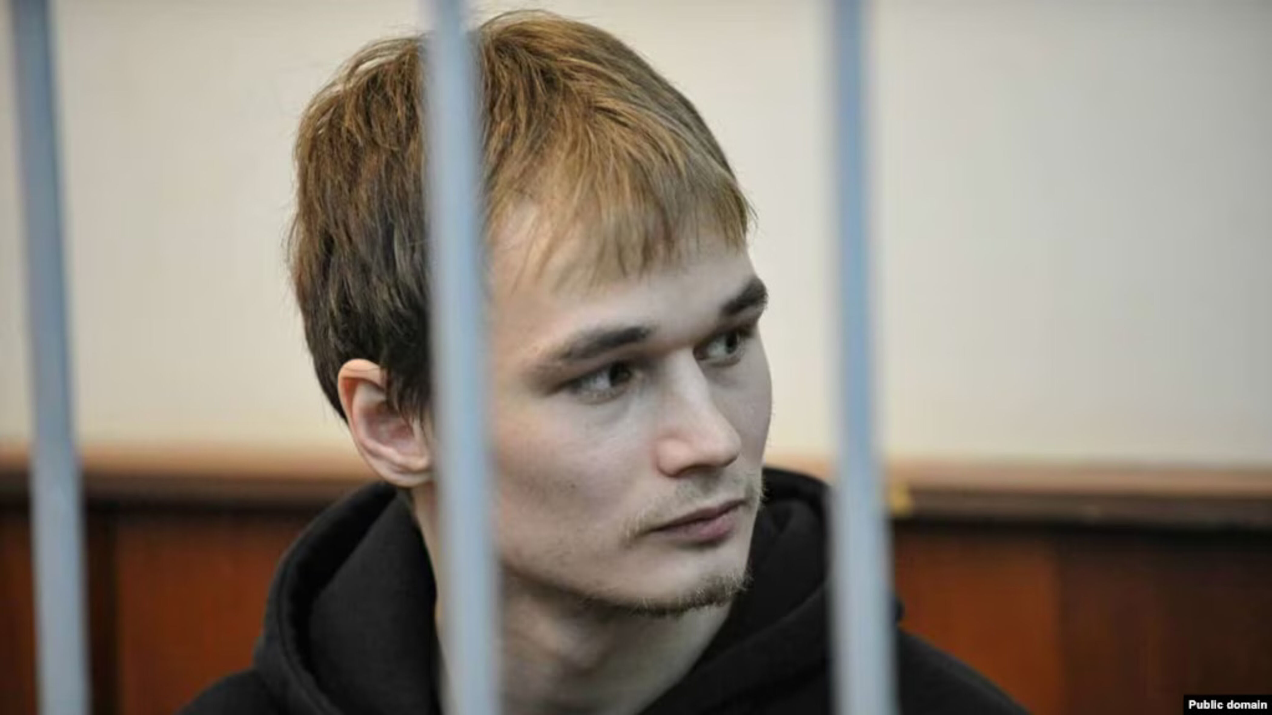 Das Foto zeigt Azat Miftakhov hinter Gitterstäben. Er sitzt in einem Käfig.