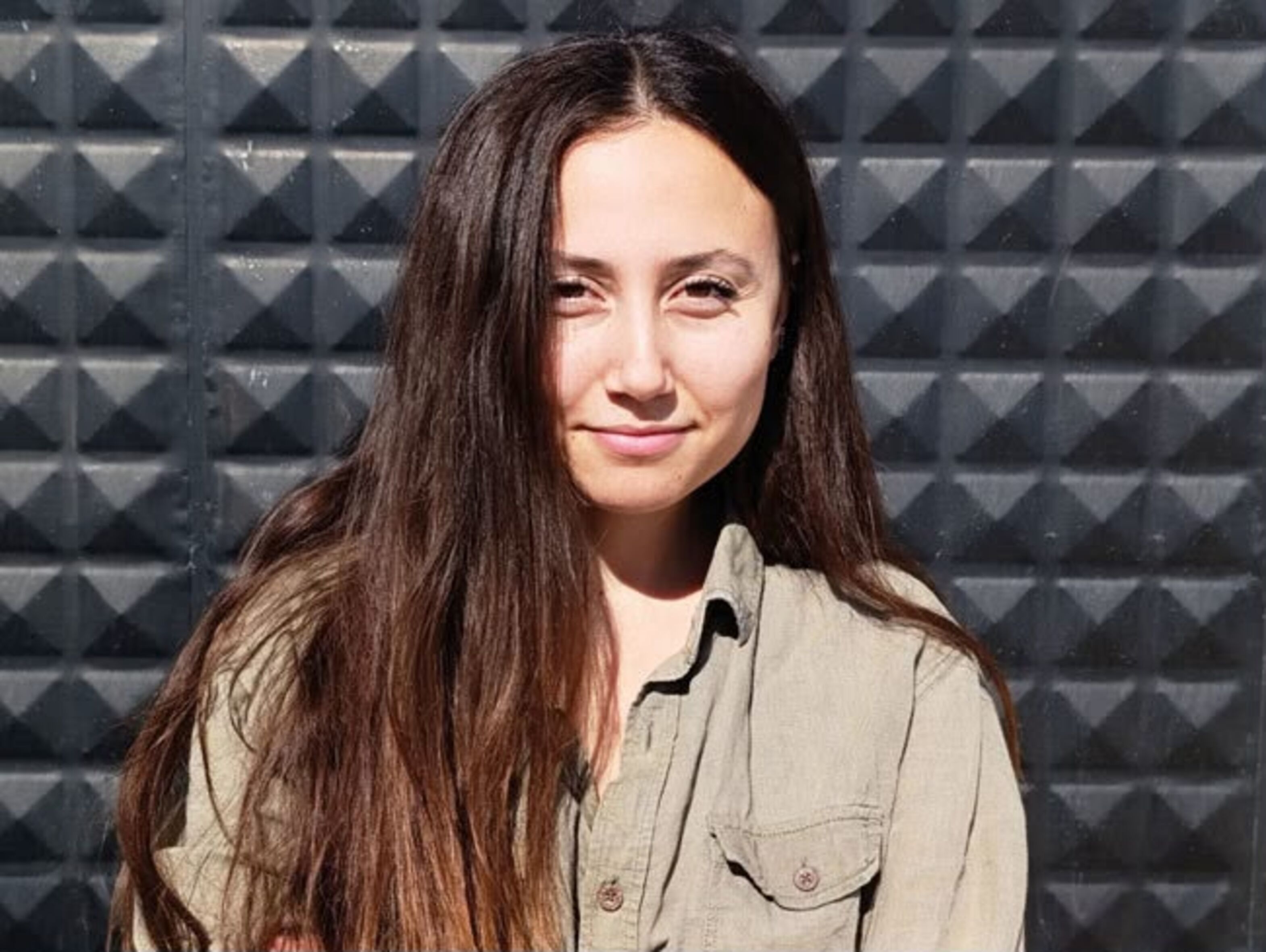 Porträtfoto von Esra Işık. Sie trägt ihr langes Haar offen und lächelt in die Kamera.