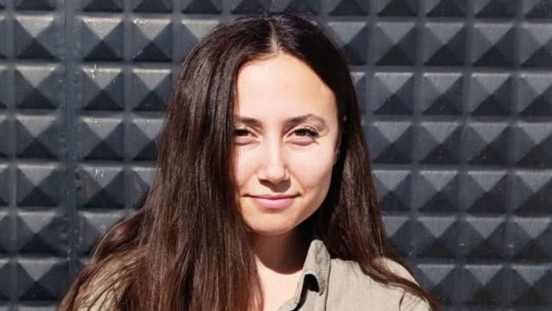 Porträtfoto von Esra Işık. Sie trägt ihr langes Haar offen und lächelt in die Kamera.