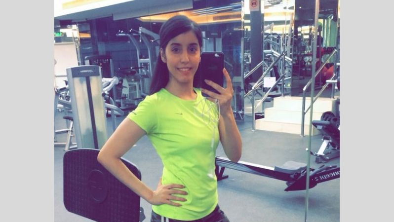 Das Bild zeigt das Selfie einer jungen Frau im Fitnessstudio