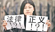 Foto: Eine chinesische Aktivistin hält Zettel mit der Aufschrift "Recht!?!", "Gerechtigkeit!?!", Beijing, März 2010.