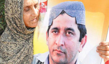 Mutter hält Plakat mit Muzaffar Bhutto