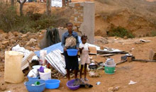 Familie vor zerstörten Häusern in der Gemeinde Kiamba Kiaxi in Luanda, Angola, 2004