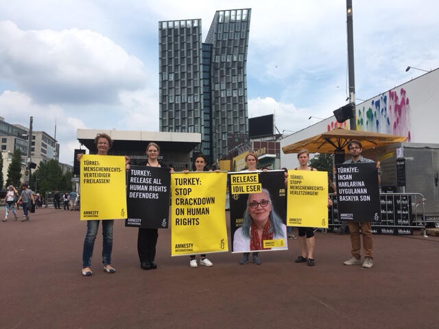 Amnesty-Mitgliedern mit Schildern auf einem Platz