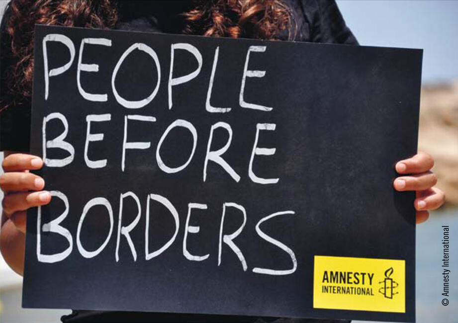 Ein Schild mit der Aufschrift "People before borders" wird ins Bild gehalten