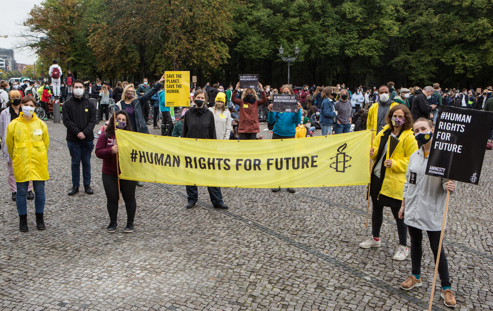 Amnesty-Aktive bei der Klimademo, sie tragen Schilder und ein Banner mit der Aufschrift "#Human Rights for Future"