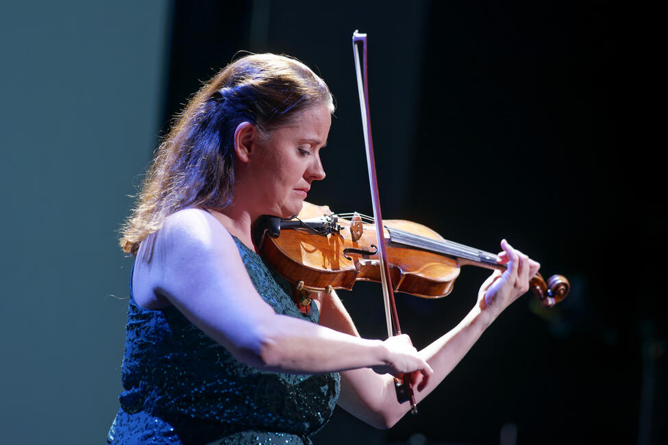 Das Bild zeigt eine Violinistin auf einer Bühne