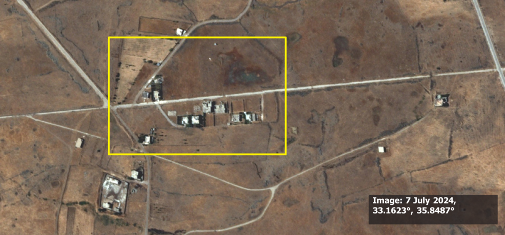 Satellitenbild von Al-Hamidiya vom 7. Juli 2024. Ein gelbes Rechteck markiert intakte zivile Gebäude und Strukturen in einer trockenen, landwirtschaftlich geprägten Landschaft, bevor militärische Aktivitäten stattfanden.