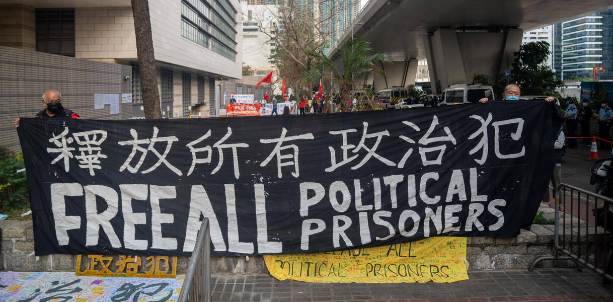 Das Bild zeigt ein großes Protest-Banner "Free all political prisoners"
