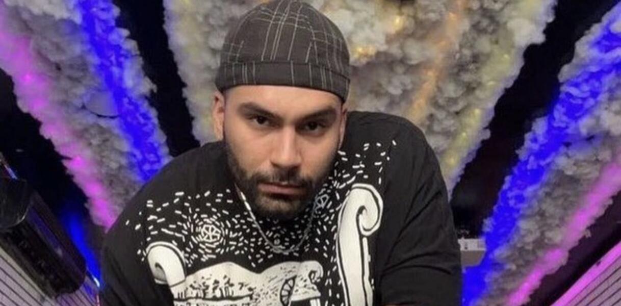 Porträtaufnahme von Mohsen Shekari, der eine Mütze trägt und ein kurzärmliges T-Shirt und ernst in die Kamera blickt.