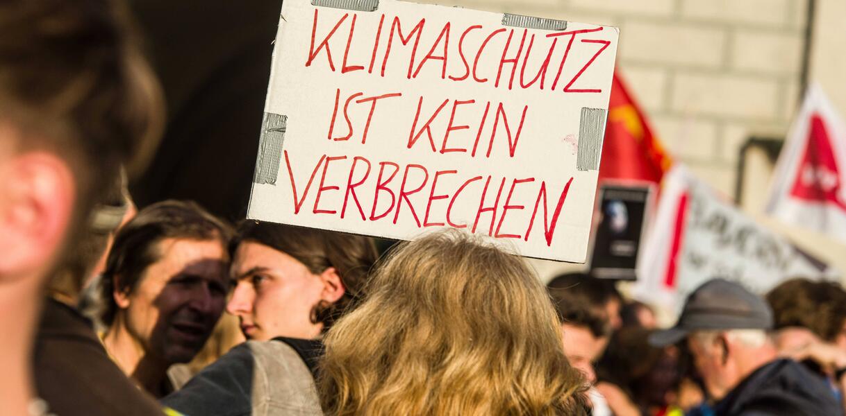 Das Bild zeigt ein Protestschild auf dem steht: "Klimaschutz ist kein Verbrechen"