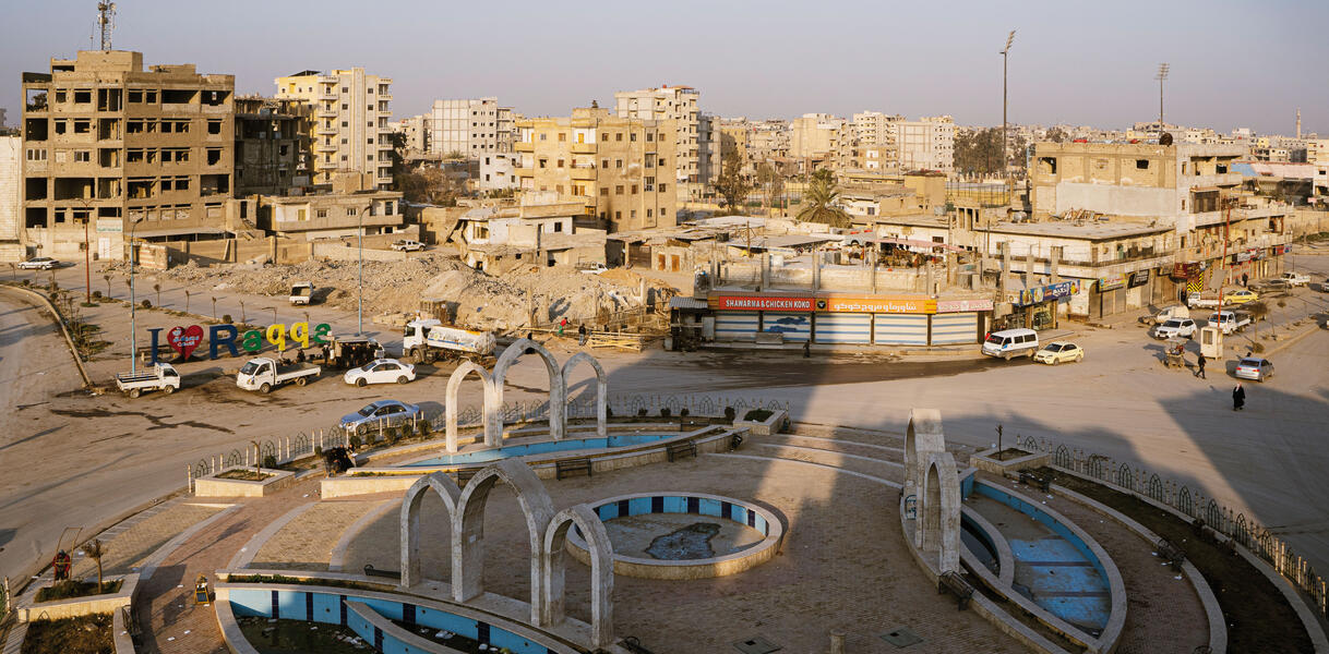 Der Naim-Platz im syrischen Rakka: ein Rondell, Kreisverkehr, darum Autos, viele zerstörte Gebäude ringsum.