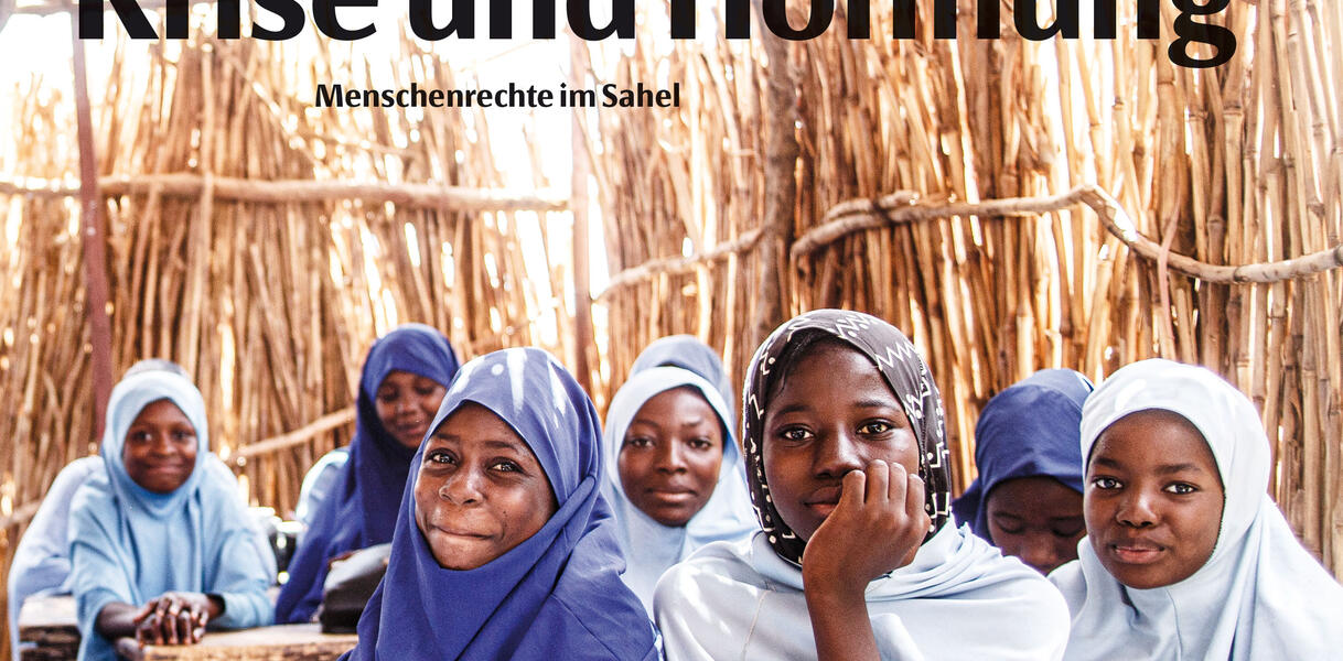 Frauen (POC) sitzen in einer Strohhütte zusammen an Schultischen, auf denen aufgeschlagene Bücher liegen, sie tragen Kopftücher. Schriftzug "Amnesty Journal" und "Krise und Hoffnung – Menschenrechte im Sahel".