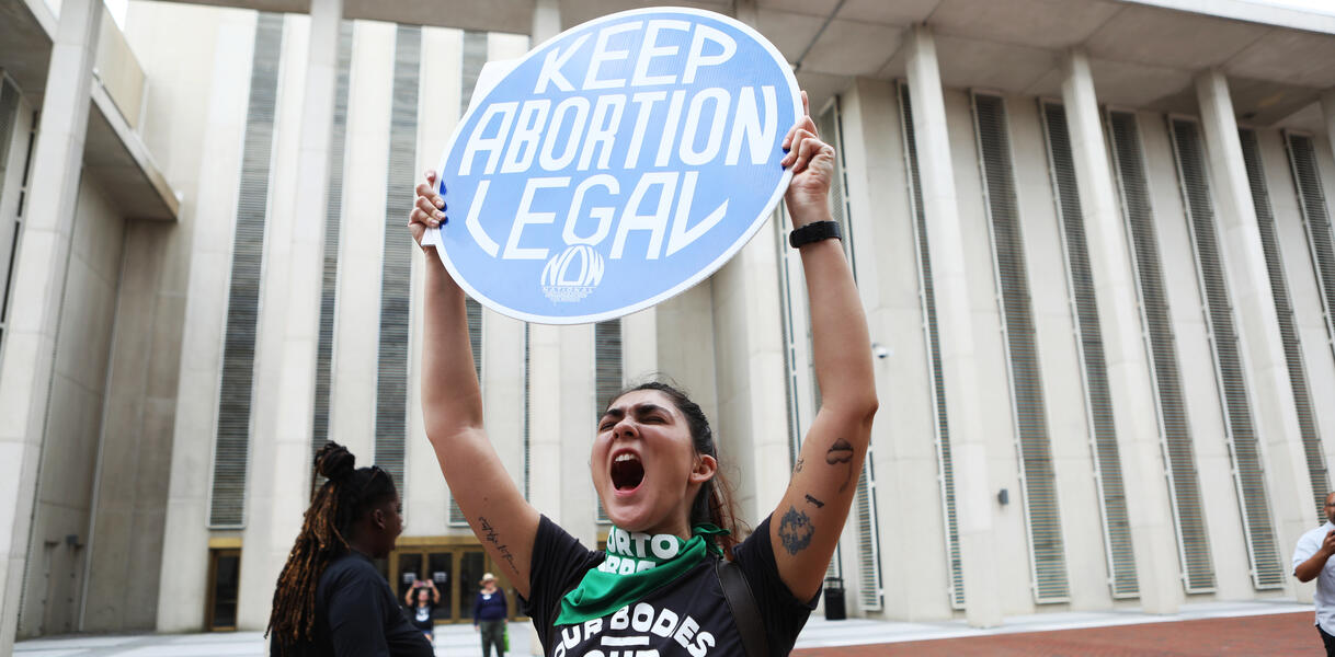 Eine Frau hält ein Schild hoch auf dem steht: "Keep abortion legal". 