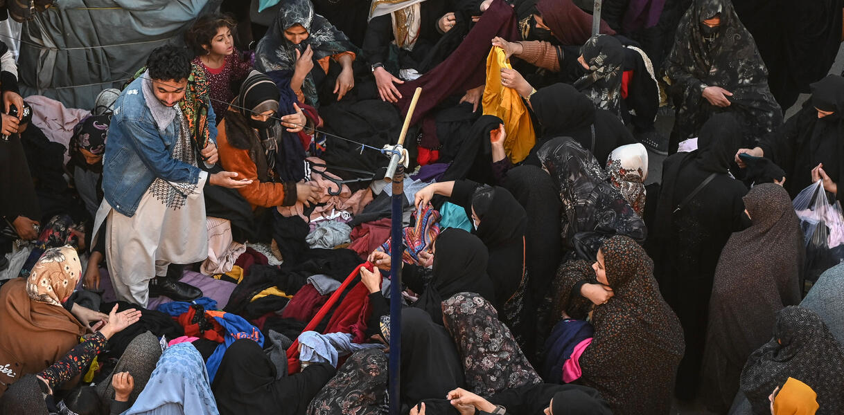 Afghanische Menschen auf einem Markt suchen Klaiedung aus.