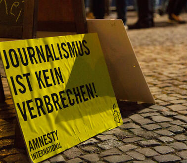 Protestschild mit der Aufschrift "Journalismus ist kein Verbrechen" steht auf dem Boden