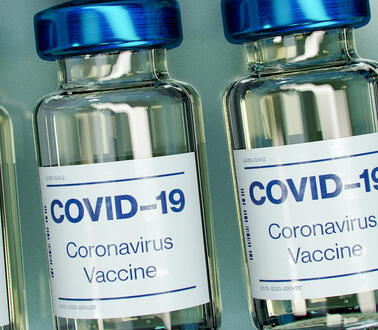 Das Bild zeigt eine Nahaufnahmen von vier Fläschchen mit Impfstoff gegen das Coronavirus.