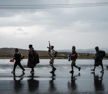 Soldaten laufen in einer Reihe über eine Straße.