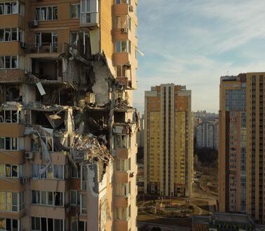  Das Foto zeigt die Außenaufnahme eines Hochhaus, bei dem mehrere Stockwerke durch einen Raketenangriff komplett zerstört wurden.