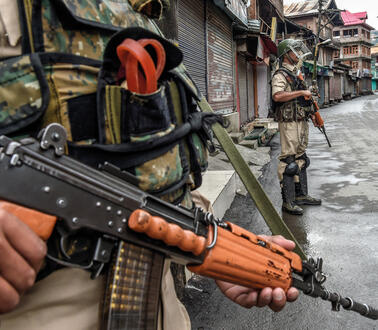Eine Militärpatrouille mit Maschinengewehren steht auf einer Straße in Kaschmir.